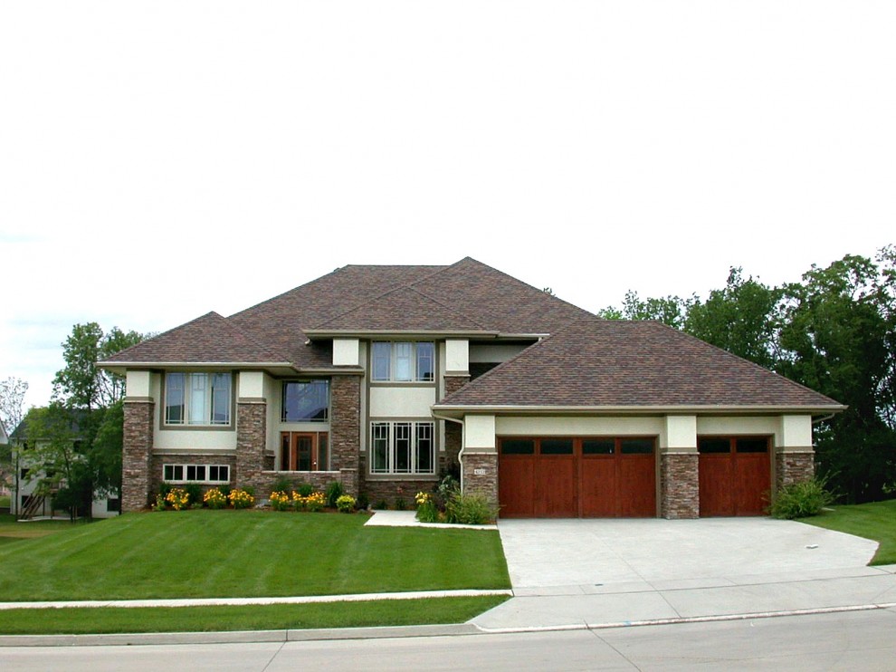 Cette image montre une façade de maison design en pierre avec un toit à quatre pans.