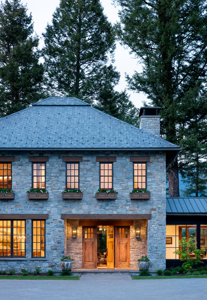 Пример оригинального дизайна: большой, двухэтажный, серый частный загородный дом в классическом стиле с облицовкой из камня