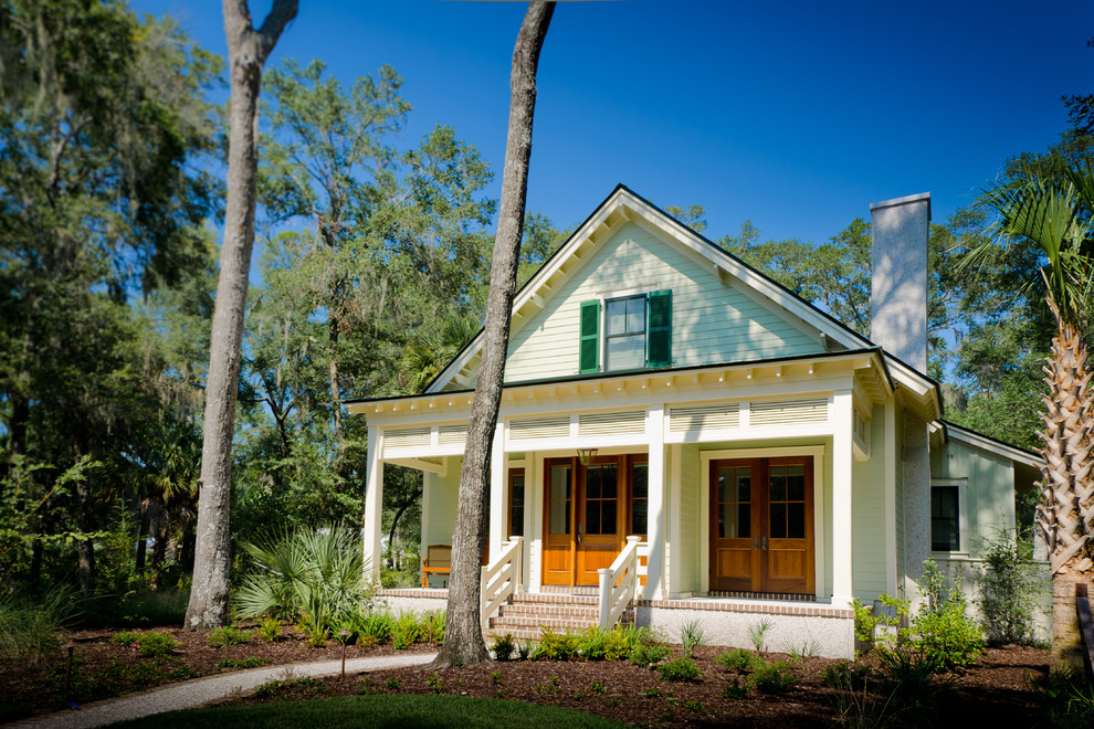 Idee per la facciata di una casa tropicale con rivestimento in legno e tetto a capanna