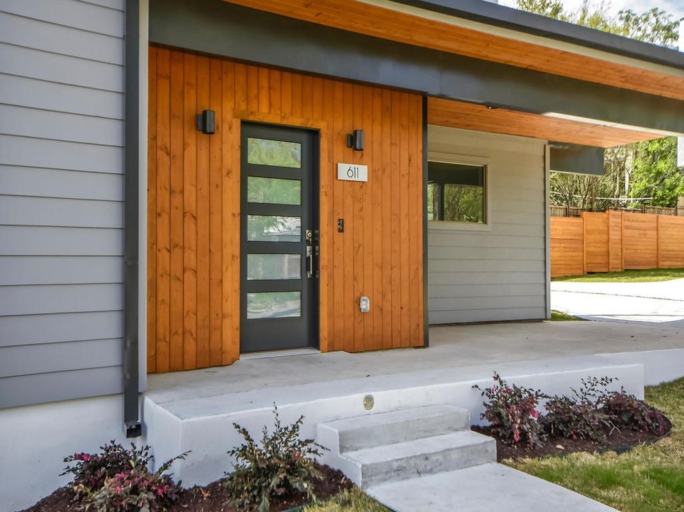 Mittelgroßes, Zweistöckiges Modernes Einfamilienhaus mit Mix-Fassade, grauer Fassadenfarbe und Flachdach in Austin