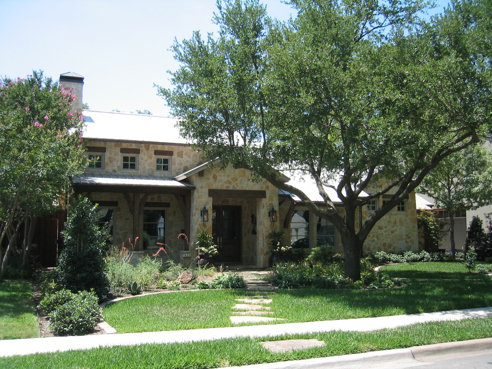 Immagine della facciata di una casa rustica con rivestimento in pietra