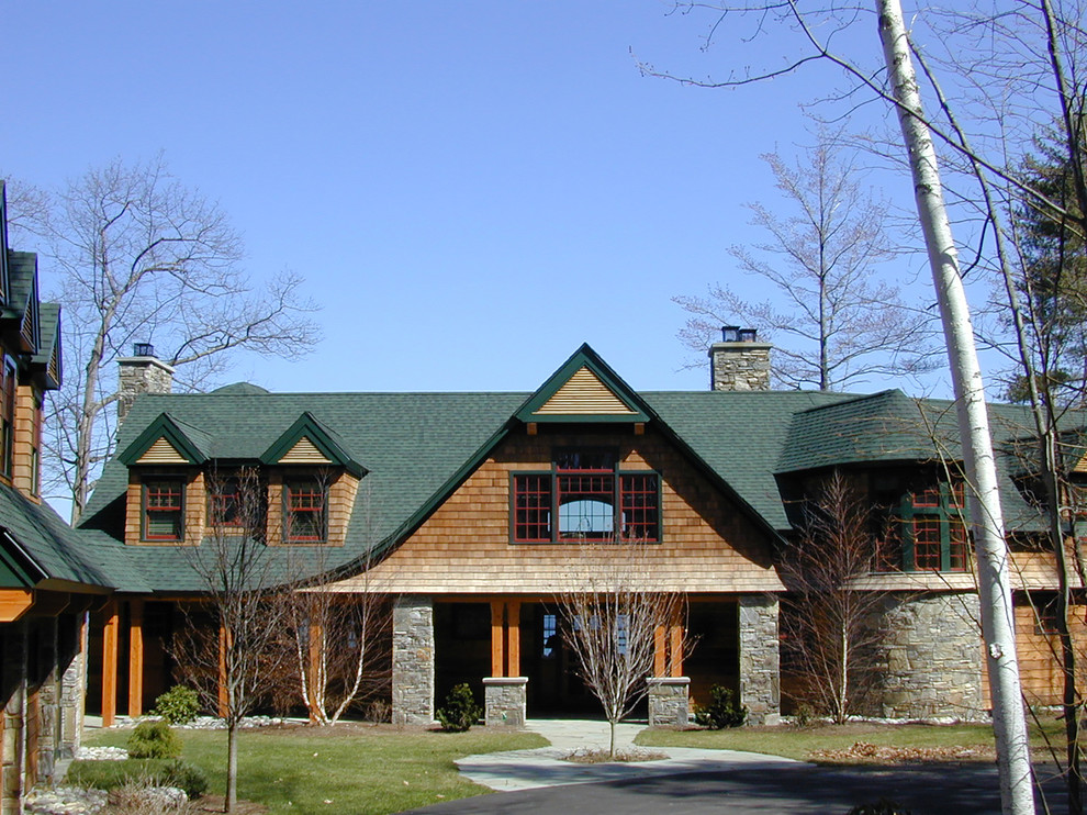 Ejemplo de fachada marrón rústica grande de dos plantas con revestimiento de madera y tejado a dos aguas
