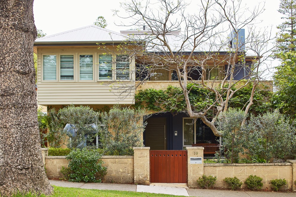Imagen de fachada de casa beige costera grande de dos plantas con revestimientos combinados, tejado a cuatro aguas y tejado de metal