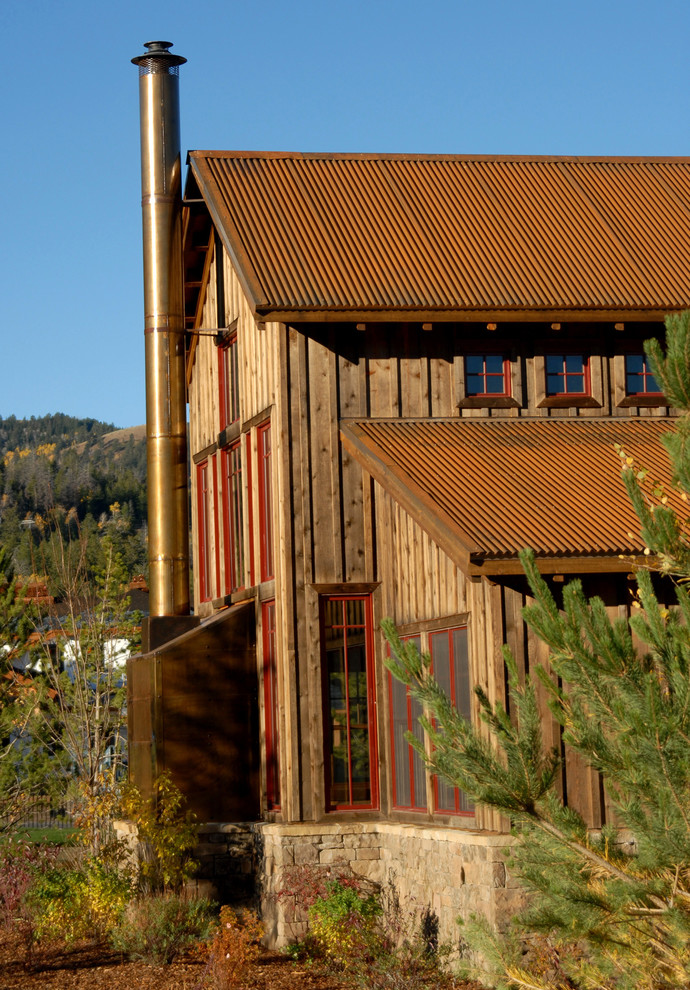 Cette photo montre une grande façade de maison marron montagne en bois à un étage avec un toit à deux pans et un toit en métal.