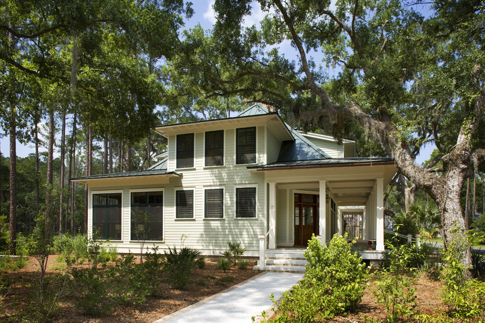 Esempio della facciata di una casa verde classica a due piani di medie dimensioni con rivestimento in legno e tetto a capanna