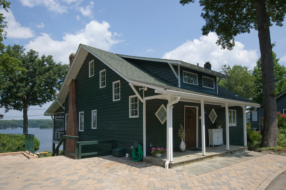 This is an example of a medium sized and green traditional two floor house exterior in Baltimore with wood cladding and a pitched roof.