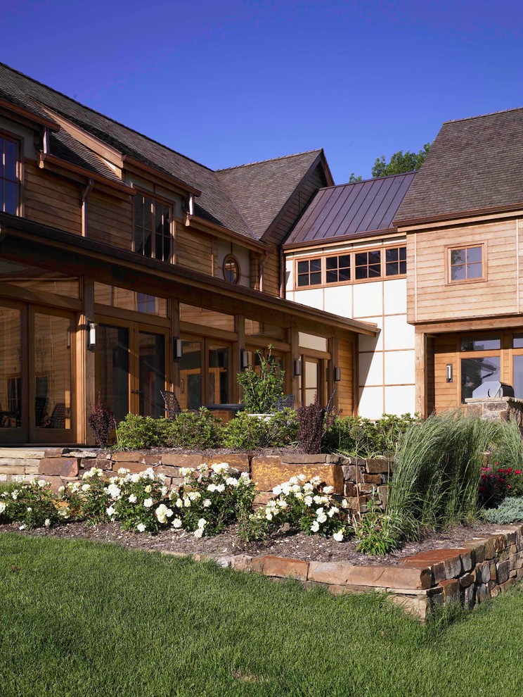 Идея дизайна: огромный, трехэтажный, деревянный, коричневый частный загородный дом в стиле рустика с двускатной крышей и крышей из смешанных материалов