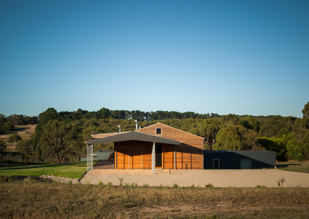 Diseño de fachada de casa minimalista grande a niveles con revestimiento de madera, tejado a dos aguas y tejado de metal