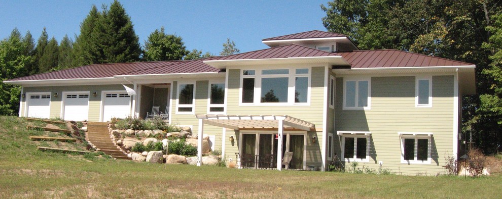 Idée de décoration pour une façade de maison beige tradition en panneau de béton fibré à un étage avec un toit à quatre pans.