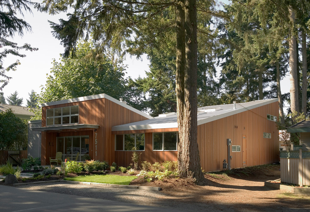 This is an example of a contemporary two floor house exterior in Seattle with wood cladding and a lean-to roof.
