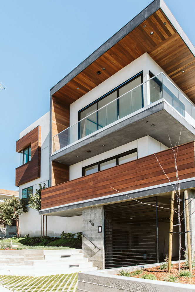 Inspiration pour un grande façade d'immeuble design en bois avec un toit plat et un toit mixte.
