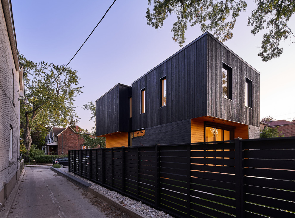This is an example of a black scandinavian detached house in Vancouver with wood cladding.