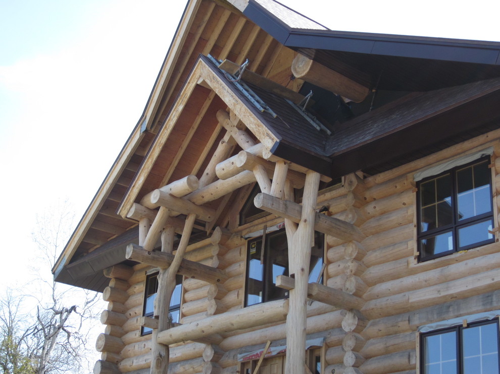 Modelo de fachada marrón rural de tamaño medio de dos plantas con revestimiento de madera y tejado a doble faldón