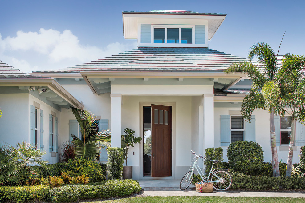 Inspiration for a white beach style detached house in Miami with a hip roof and a shingle roof.