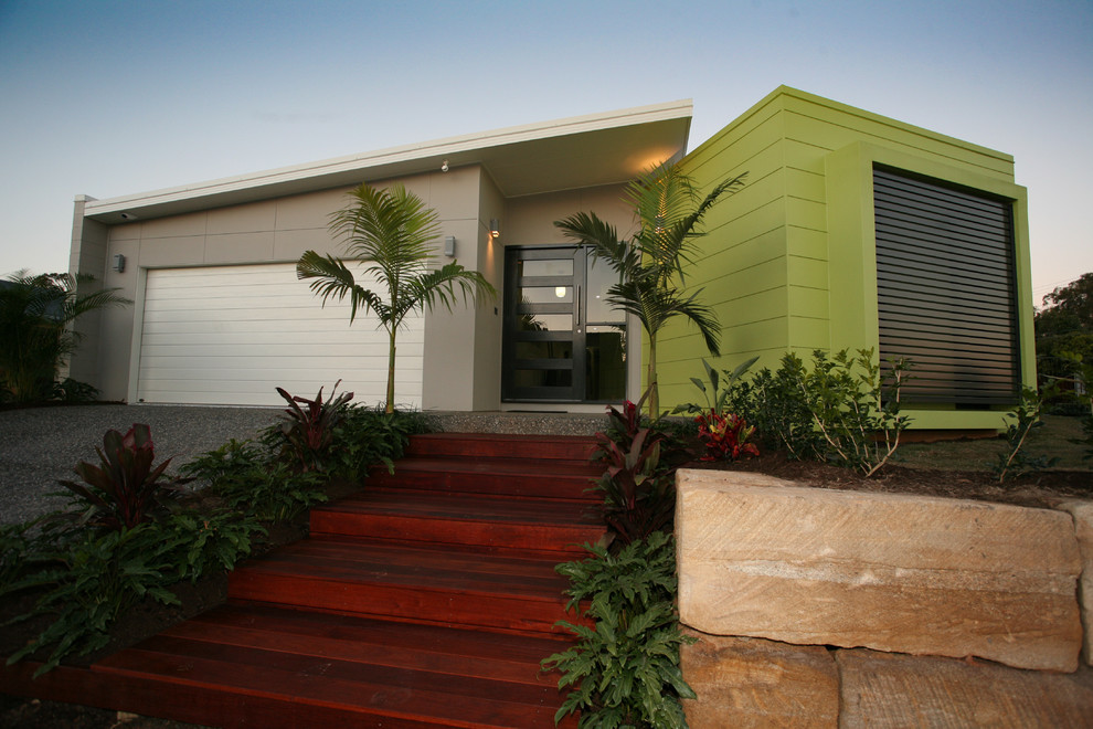 Réalisation d'une petite façade de maison verte design de plain-pied avec un revêtement en vinyle.