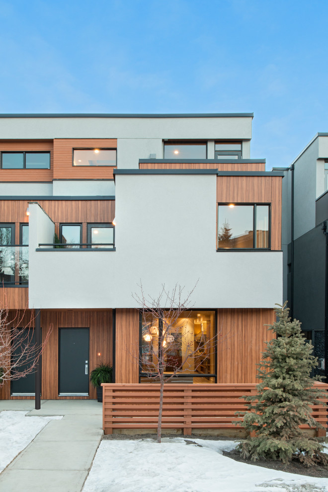 Cette image montre une façade de maison design en bois à deux étages et plus.