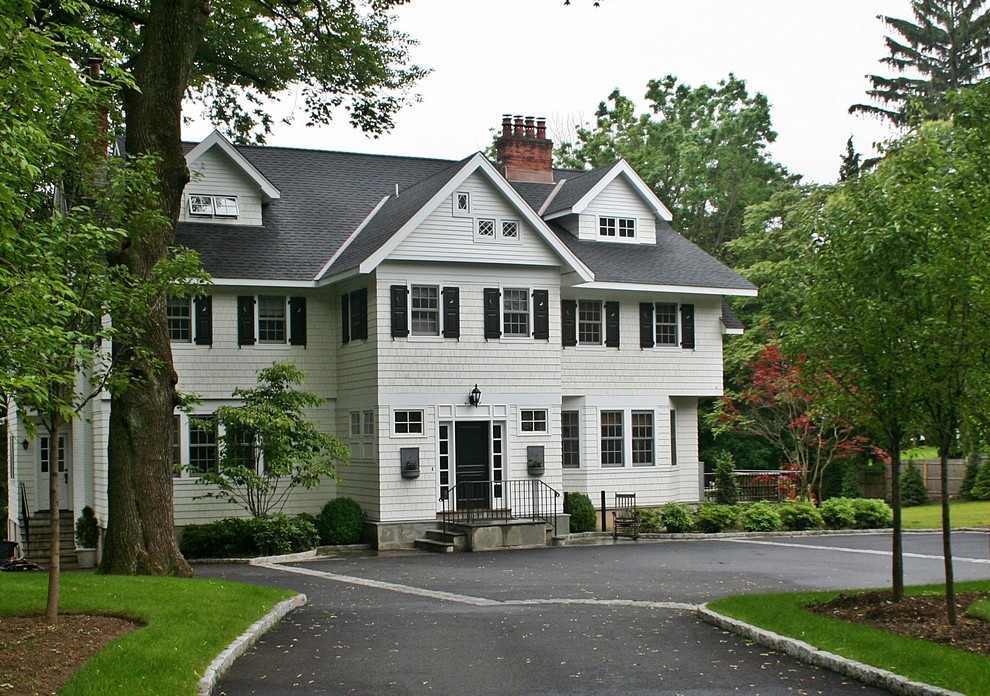 Immagine della facciata di una casa grande bianca classica a tre piani con rivestimento in legno e tetto a capanna