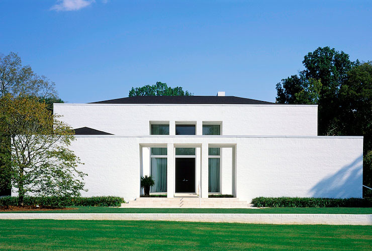 Cette image montre une grande façade de maison blanche minimaliste en brique à un étage avec un toit à quatre pans.
