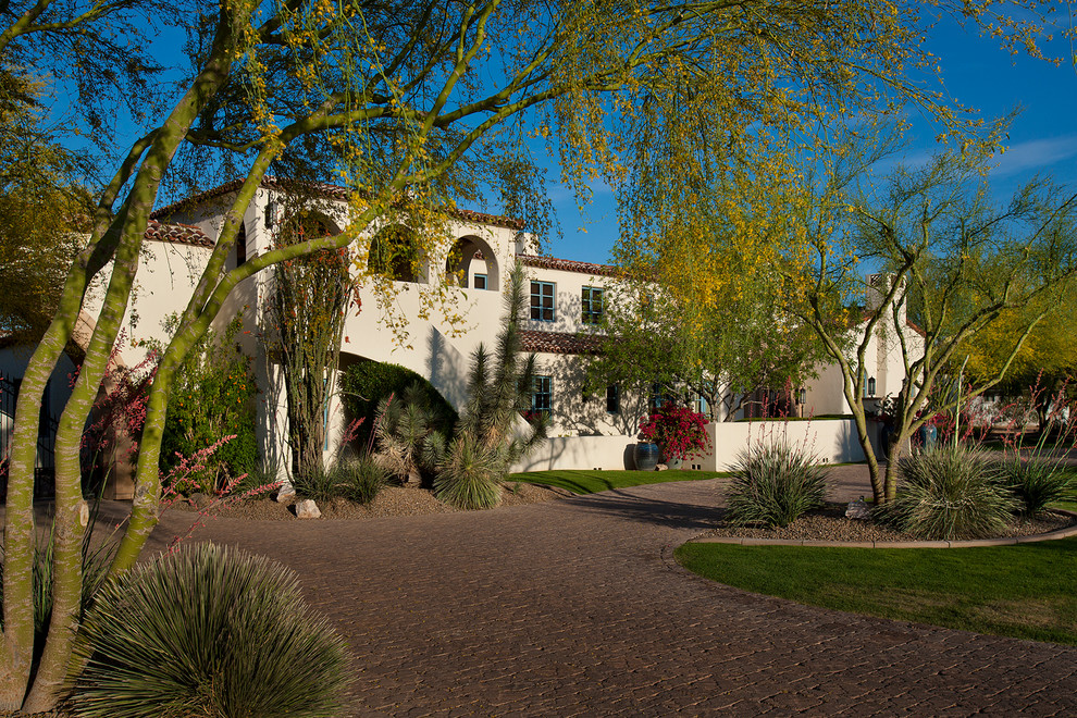 Inspiration for a large mediterranean white two-story stucco exterior home remodel in Phoenix with a tile roof