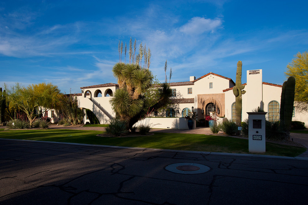 Example of a large tuscan white two-story stucco gable roof design in Phoenix