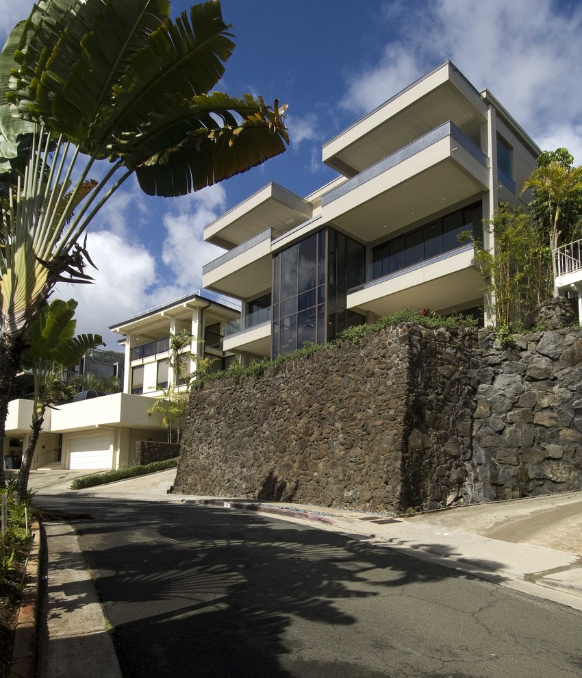 Design ideas for a large and white modern render detached house in Hawaii with three floors and a flat roof.