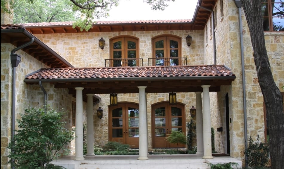 Foto della villa grande multicolore mediterranea a due piani con rivestimento in pietra e copertura in tegole