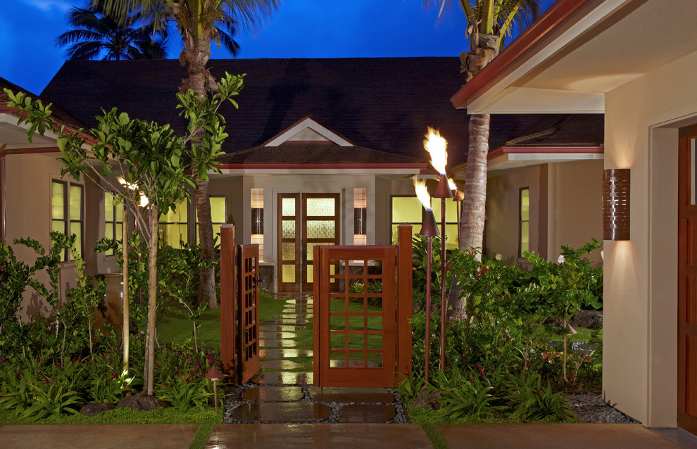 ハワイにあるラグジュアリーなトロピカルスタイルのおしゃれな家の外観 (漆喰サイディング) の写真