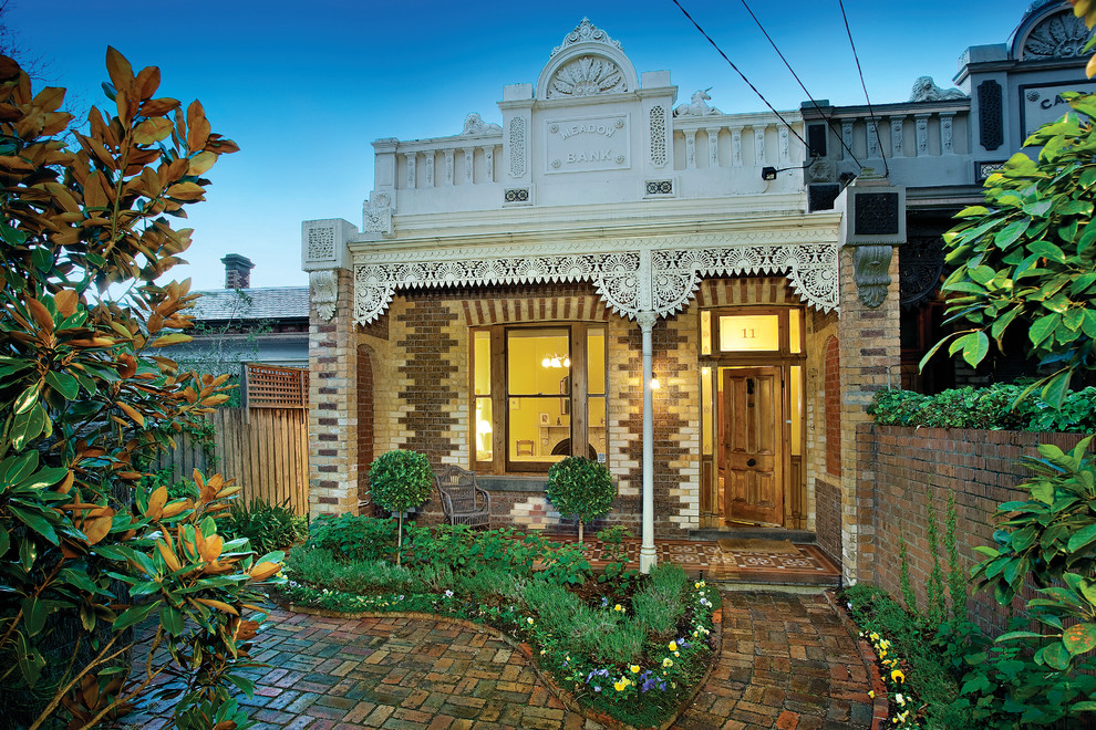 Пример оригинального дизайна: маленький, одноэтажный, кирпичный, бежевый дом в викторианском стиле для на участке и в саду