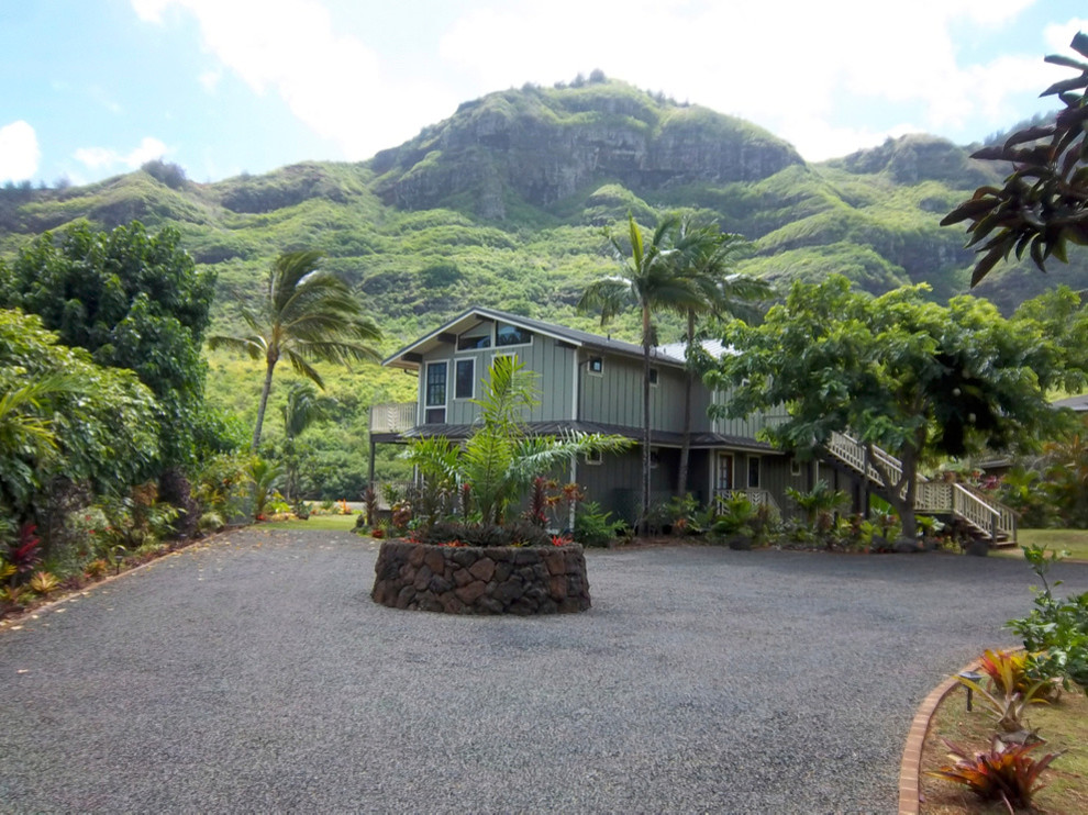 Large world-inspired two floor detached house in Hawaii with wood cladding, a pitched roof and a metal roof.