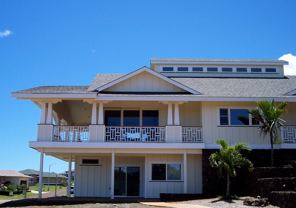 Ejemplo de fachada de casa beige costera grande de dos plantas con revestimiento de madera, tejado a dos aguas y tejado de teja de madera