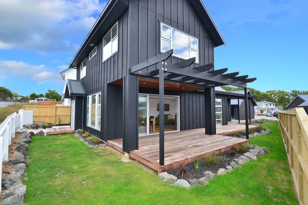 Inspiration pour une façade de maison noire design en bois de taille moyenne et à un étage avec un toit à deux pans.