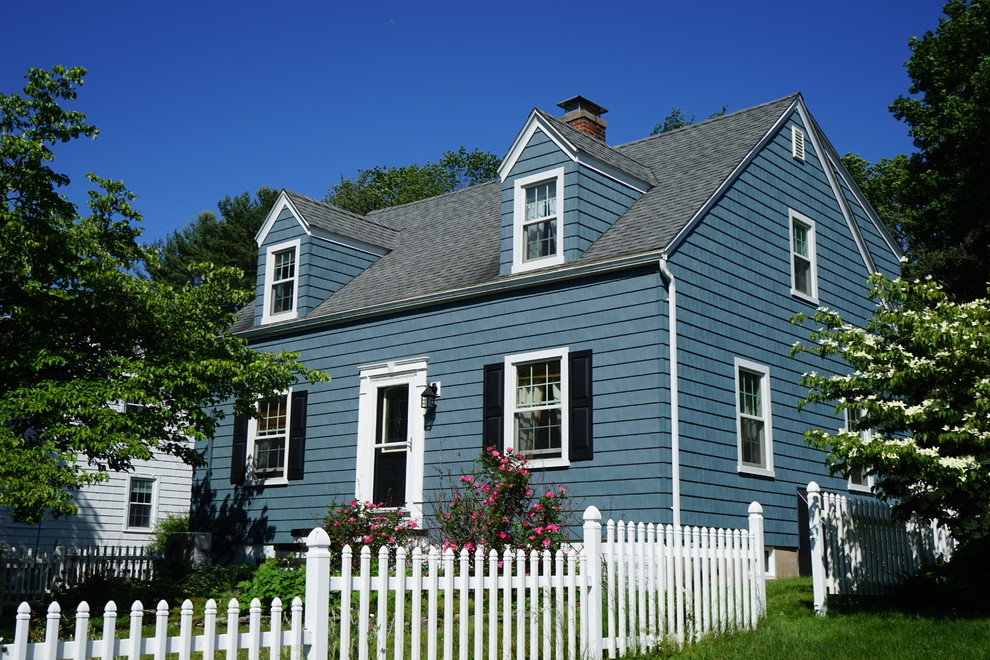 Esempio della facciata di una casa piccola blu a due piani con rivestimento in vinile