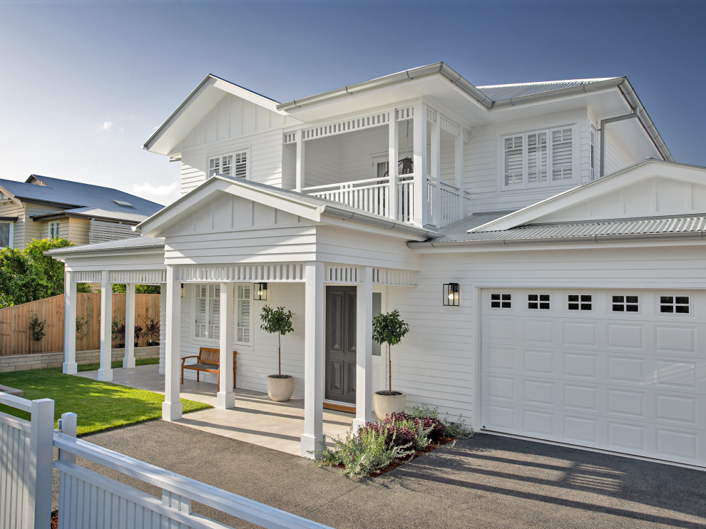 Diseño de fachada de casa blanca costera grande de dos plantas con revestimiento de aglomerado de cemento, tejado a dos aguas y tejado de metal
