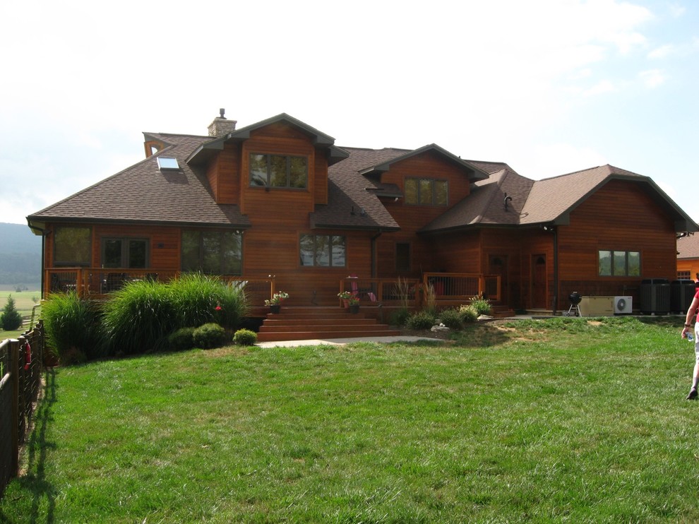 Idee per la villa grande marrone rustica a due piani con rivestimento in legno, tetto a padiglione e copertura a scandole