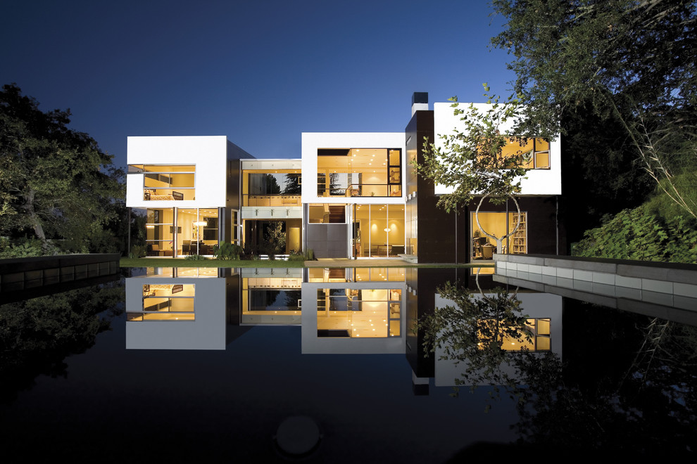 Inspiration för stora moderna vita hus, med två våningar, metallfasad och platt tak