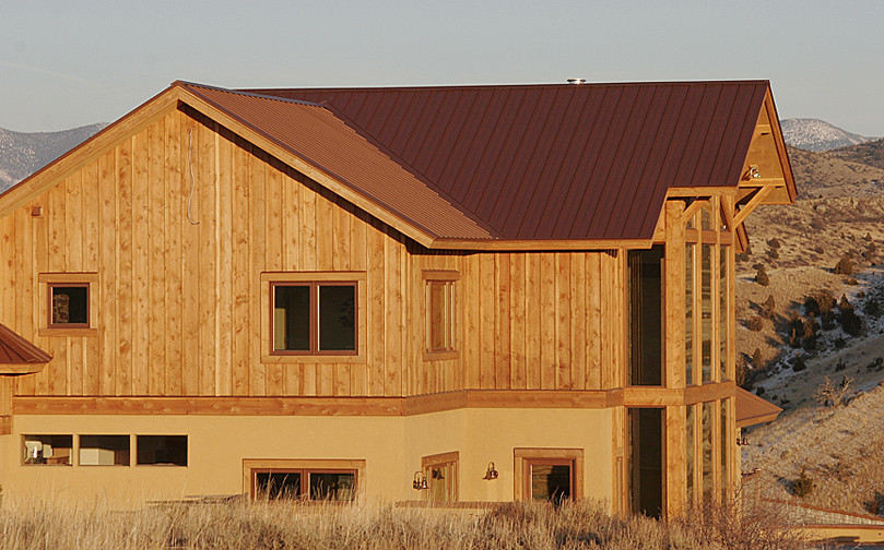 На фото: большой, двухэтажный, деревянный частный загородный дом в стиле фьюжн с металлической крышей с