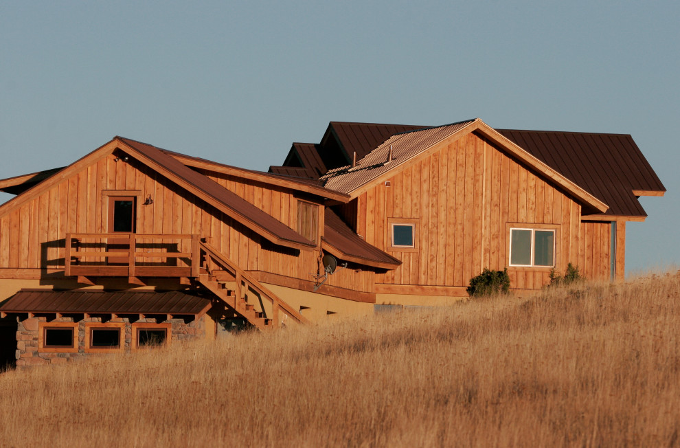 Idées déco pour une grande façade de maison sud-ouest américain en bois à un étage avec un toit en métal.