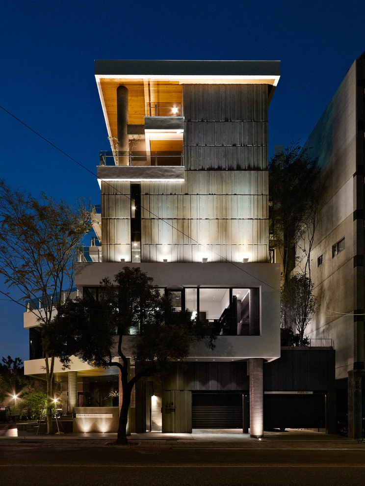 Esempio della facciata di una casa contemporanea a tre piani con rivestimento in cemento e tetto piano