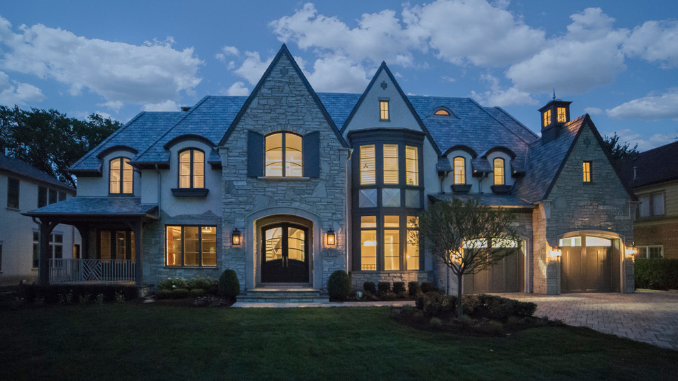 Huge transitional gray three-story stone exterior home idea in Chicago