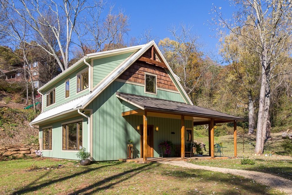 Ejemplo de fachada de casa verde de estilo de casa de campo de tamaño medio de dos plantas con revestimientos combinados, tejado a dos aguas y tejado de metal