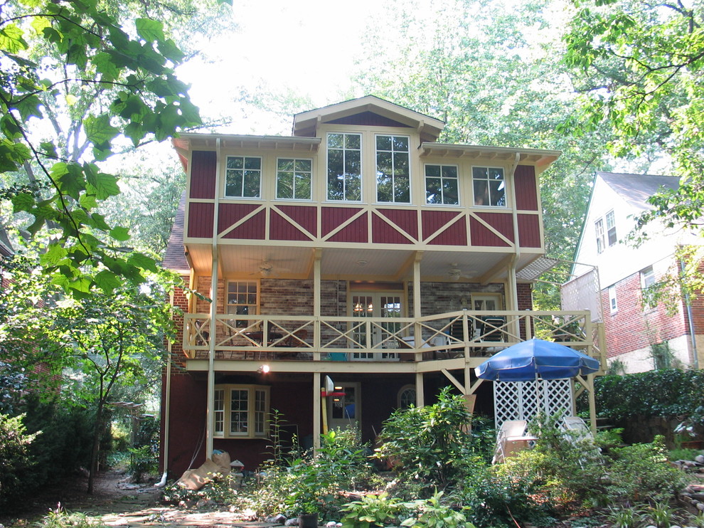 Esempio della facciata di una casa grande rossa american style a tre piani con rivestimenti misti e tetto a capanna