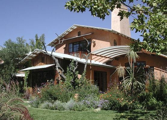 Стильный дизайн: большой, двухэтажный, розовый частный загородный дом в средиземноморском стиле с облицовкой из цементной штукатурки, двускатной крышей и металлической крышей - последний тренд