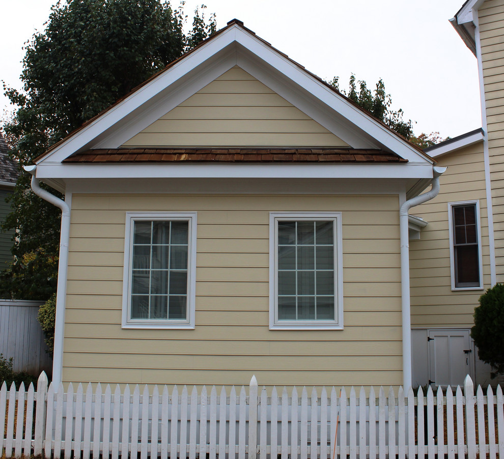 Idée de décoration pour une petite façade de maison jaune tradition de plain-pied.