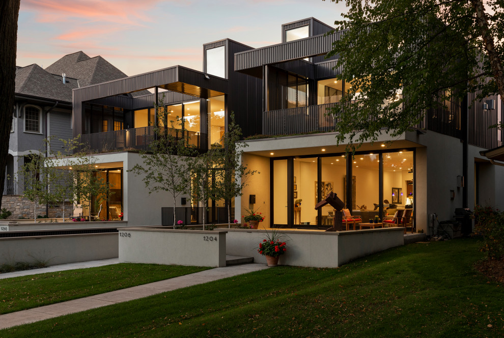 Источник вдохновения для домашнего уюта: большой, трехэтажный, черный многоквартирный дом в стиле неоклассика (современная классика) с комбинированной облицовкой, плоской крышей и зеленой крышей