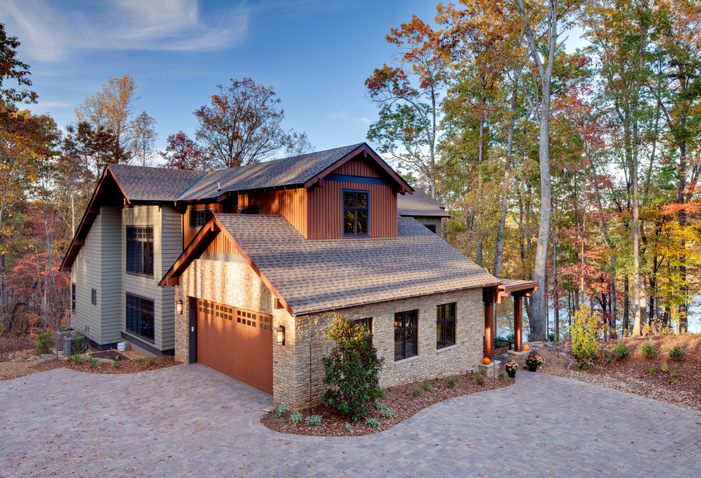 Imagen de fachada de casa multicolor actual grande de dos plantas con revestimientos combinados, tejado a cuatro aguas y tejado de teja de madera