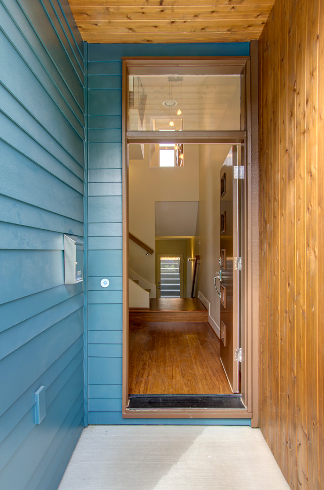 Esempio della facciata di una casa blu moderna con rivestimento in legno