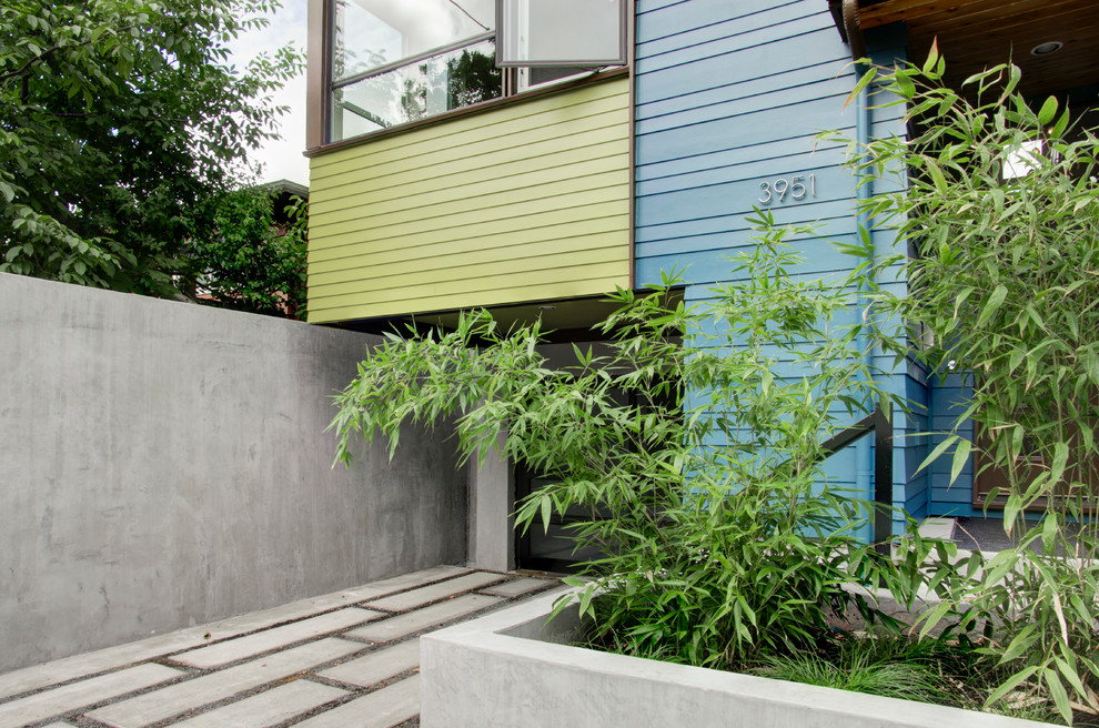 Cette photo montre une façade de maison bleue moderne en panneau de béton fibré à deux étages et plus.