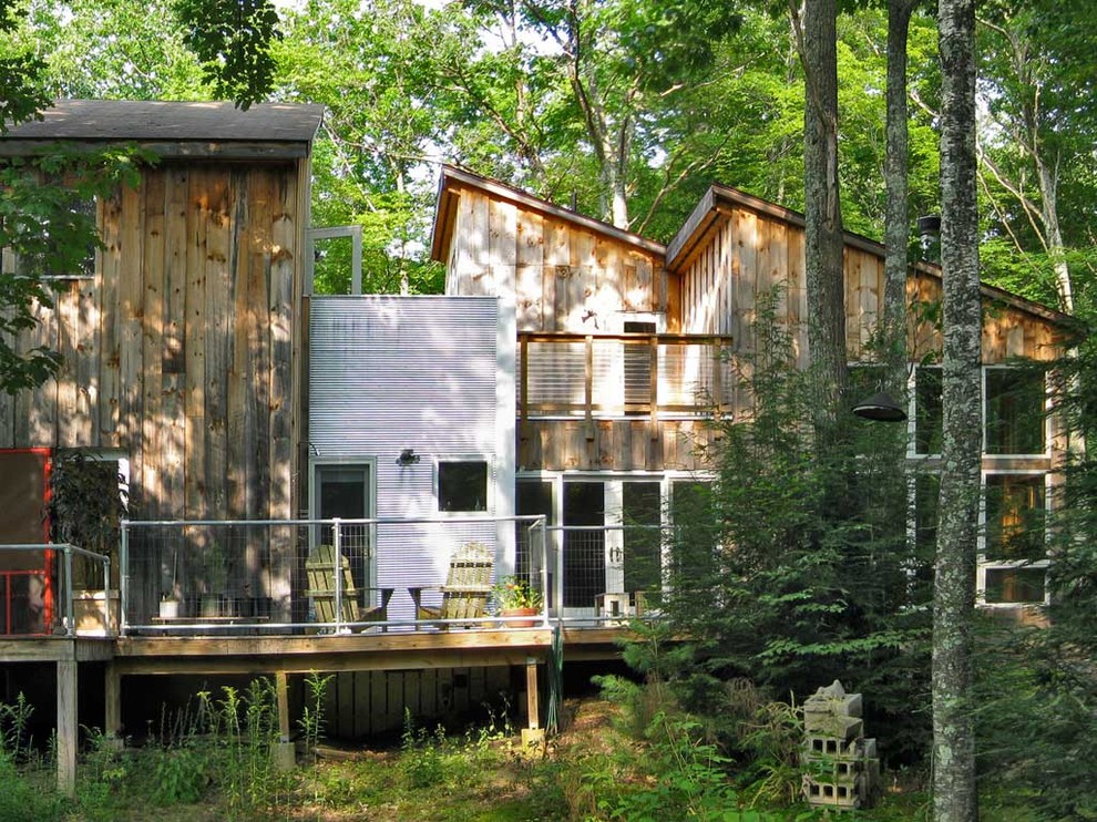 Inspiration for a rustic house exterior in New York with metal cladding and a lean-to roof.