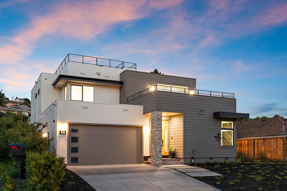 Diseño de fachada de casa gris actual de dos plantas con revestimientos combinados y tejado plano