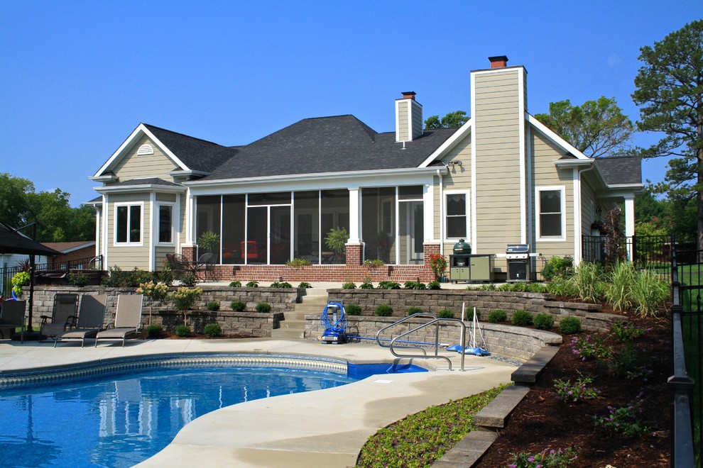 Imagen de fachada beige clásica de tamaño medio de una planta con revestimiento de aglomerado de cemento y tejado a cuatro aguas